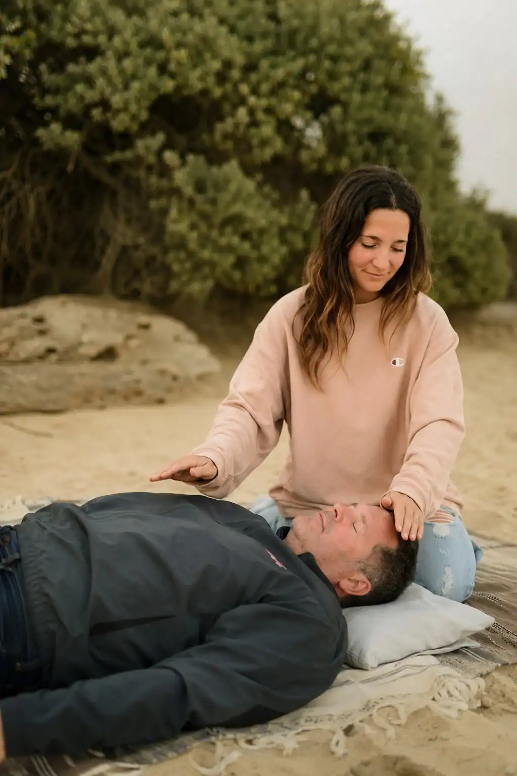 Jessica Dawson offering hands-on energy healing on the beach, Take Root Healing